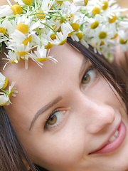 Adorable busty teen girl posing in only a wreath of daisies on her head in a sand quarry.