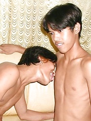Two young Asian men strips on a sofa